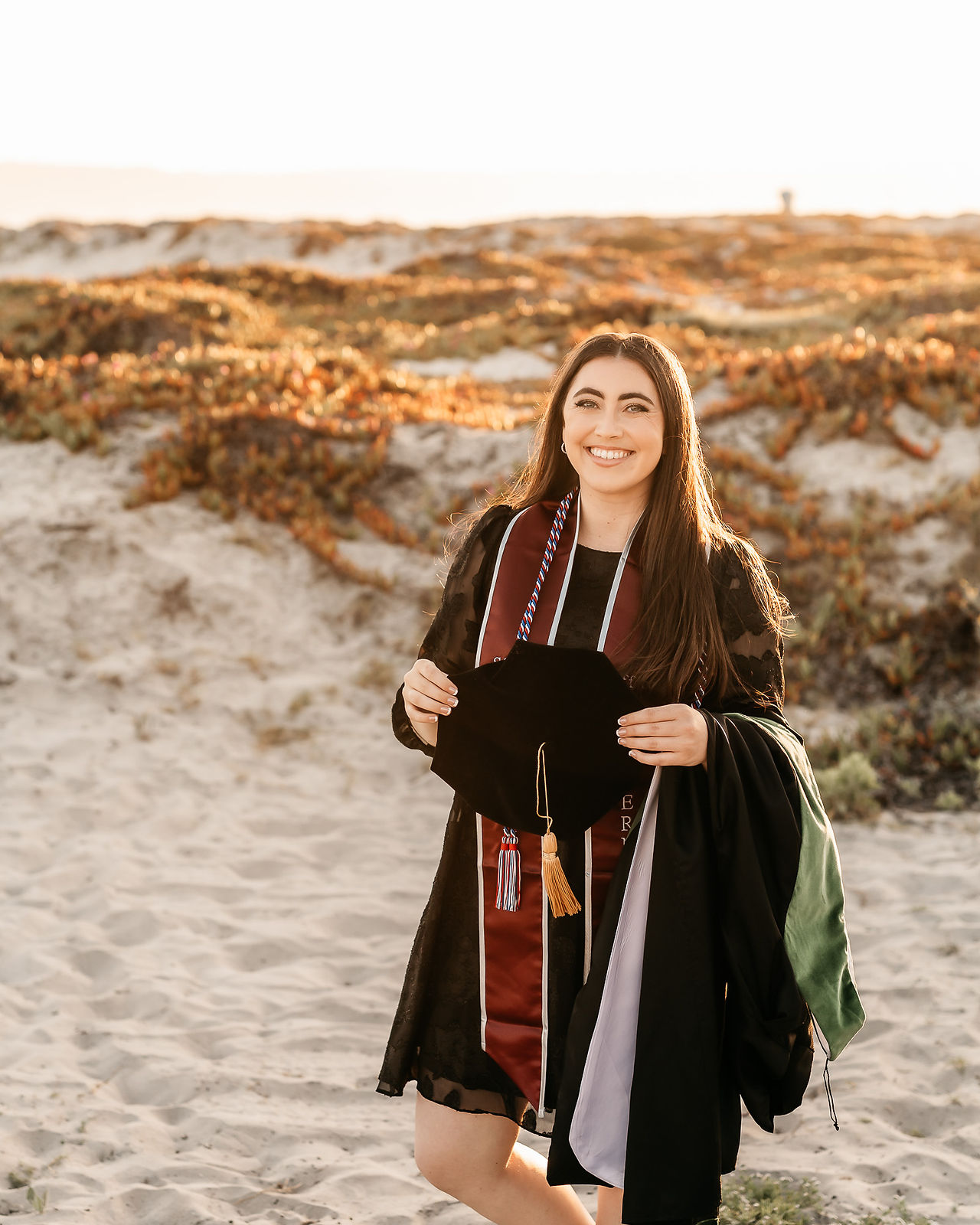 College senior photos on the beach in San Diego in cap, gown and stole