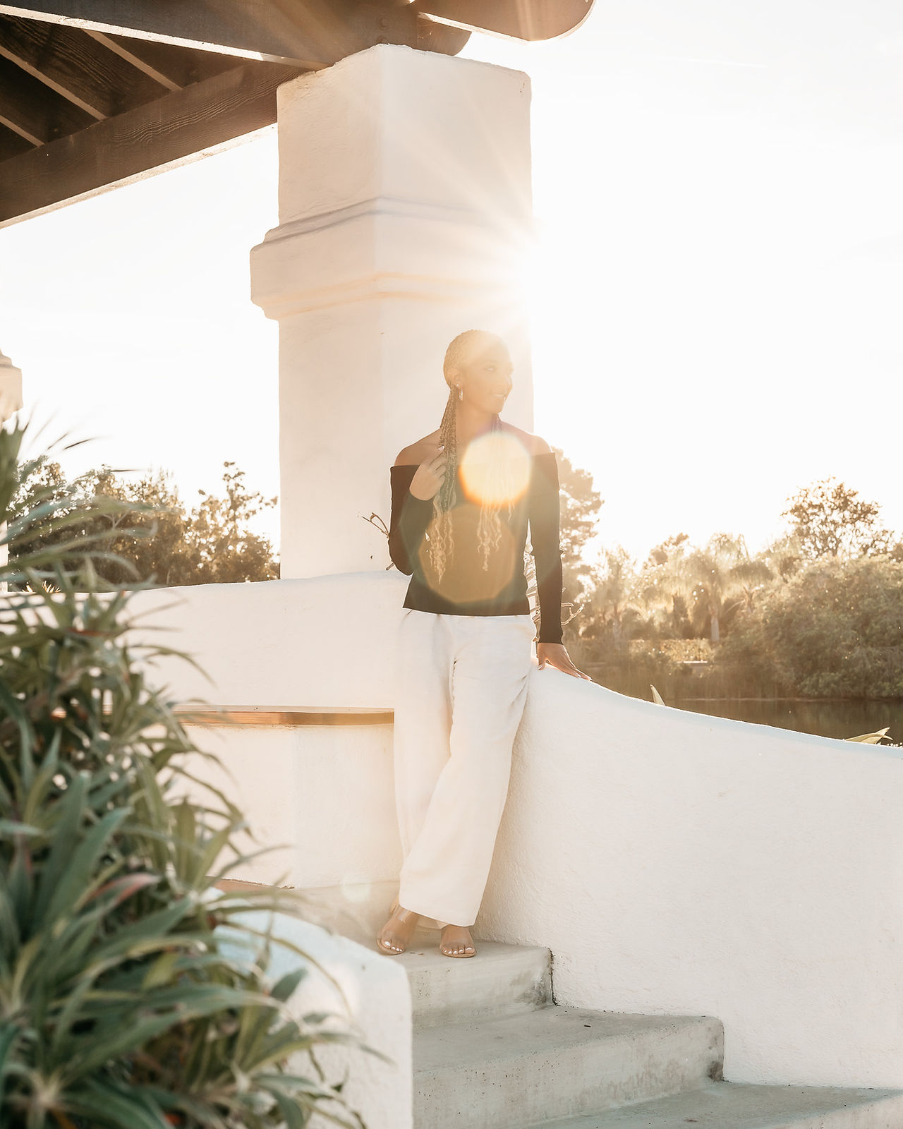 Luxury senior portraits in a San Diego park featuring a high school senior styled in neutral tones surrounded by lush greenery.
