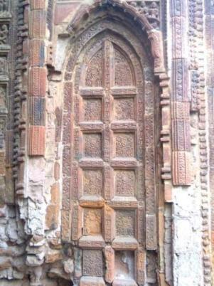 Articulation of a wooden false door in terracotta bricks and tiles