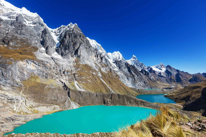 Schöner, blauer See mit einem schneebedeckten Berg im Hintergrund.