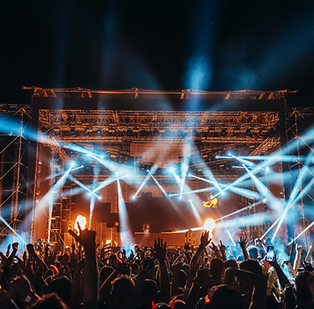 "Night music festival with live concert stage, bright laser lights, and cheering crowd at outdoor event."
