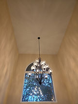 Electrician installing a modern light fixture in a Hampton Roads home