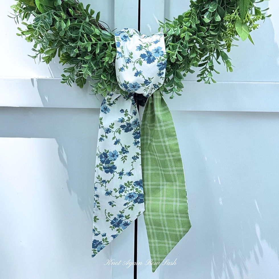 Reversible wreath sash in blue floral fabric with green plaid reverse tied simply on a seasonal wreath.