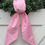 Thumbnail: The pink candy cane wreath sash displayed on a Christmas wreath against a white door, styled with winter greenery to create a