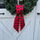 Thumbnail: Holiday red and black buffalo check wreath sash tied in a simple knot on a green Christmas wreath rustic farmhouse door decor