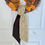Thumbnail: Reversible wreath sash in navy marigold floral with golden reverse tied simply on a seasonal wreath.