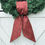 Thumbnail: Red and green holly print wreath sash tied neatly on a fresh pine wreath. Classic Christmas door décor with festive holiday c