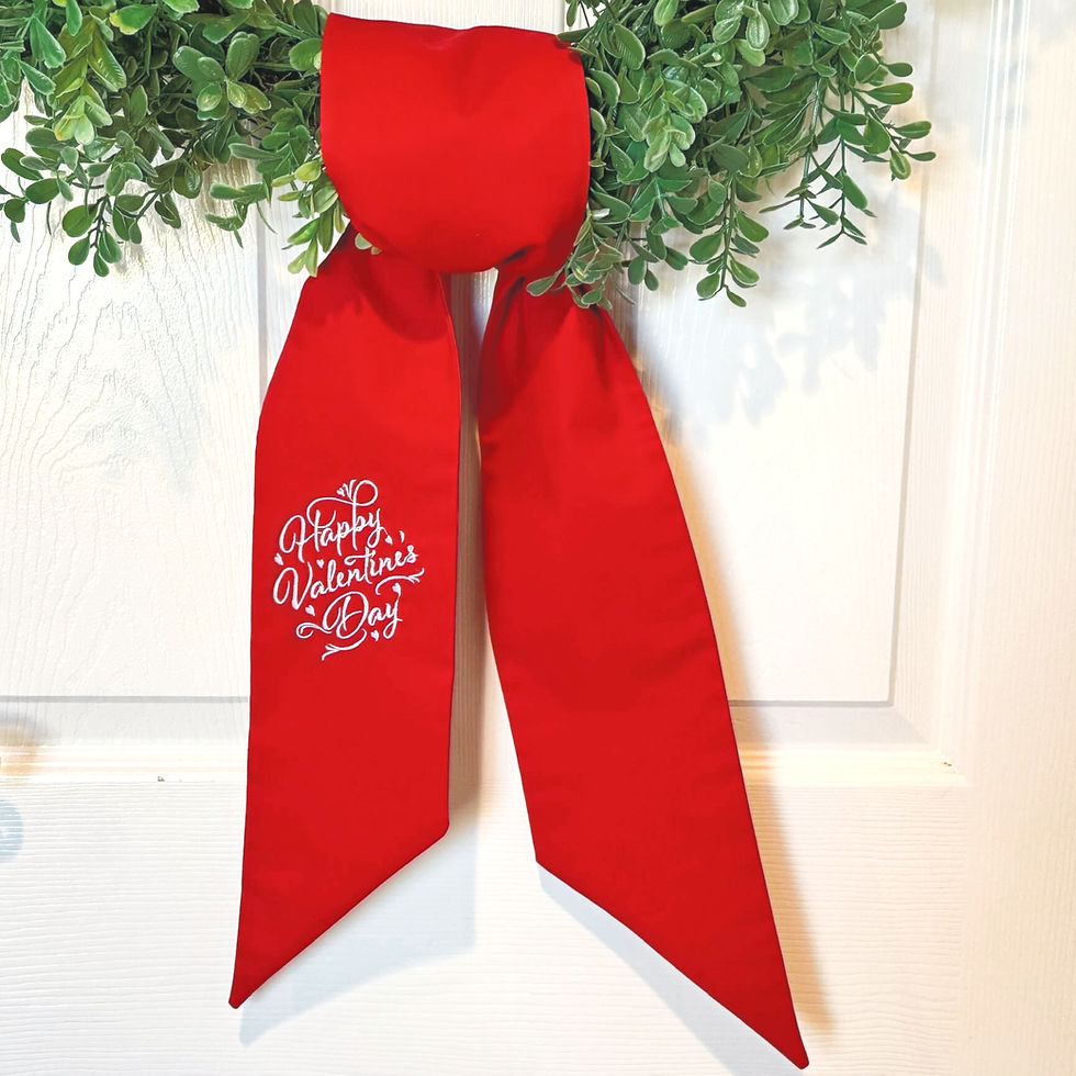 Thumbnail: Green boxwood wreath with a bright red Valentine’s Day wreath sash tied in a bow on a white front door, white script embroide
