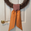 Thumbnail: orange and burgundy plaid wreath sash on a grapevine wreath for fall front door decor
