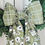 Thumbnail: CLOSE UP OF GREEN PLAID AND FLORAL KNOT AGAIN BOW SASH AFFIXED TO A GREEN BOXWOOD