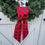 Thumbnail: Holiday red and black buffalo check wreath sash tied in a simple knot on a green Christmas wreath rustic farmhouse door decor