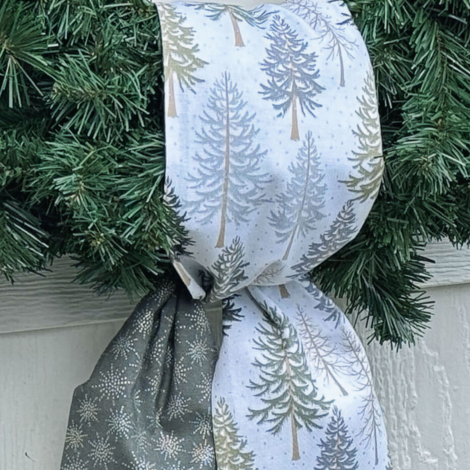 Thumbnail: Detailed close-up of the reversible fabrics — white pine tree print and coordinating silver snowflake pattern with soft textu