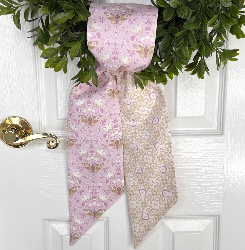 Lavender butterfly wreath sash tied in a simple knot at the base of a green wreath on a front door.