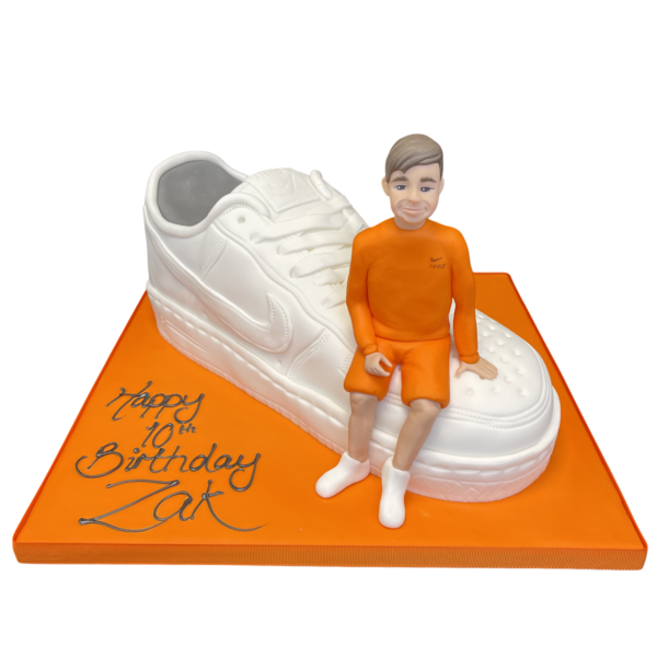A creatively designed celebration cake featuring a boy on a trainer theme, perfect for birthdays and special occasions in UK.