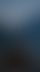 Man DJing with headphones by a river, surrounded by rocks and mountains. Text reads: "Not every track is born in a studio." Serene setting.