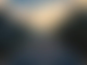 A solo traveler with a backpack stands on a peaceful Himalayan road at sunrise, gazing toward misty hills along the Delhi to Kainchi Dham route; the scene is framed by trees and soft morning light with blue, yellow, and red tones symbolizing trust, hope, and purpose.
