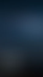 Person sits by illuminated tent under starry sky with Milky Way. Mountains in the background add to the serene, awe-inspiring scene.