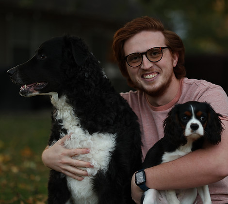 Person with red hair holding two dogs