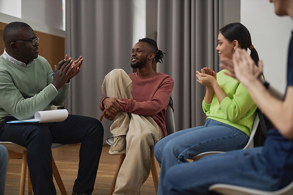 support-group-applauding-to-smiling-black-man-2023-11-27-05-07-51-utc.jpg