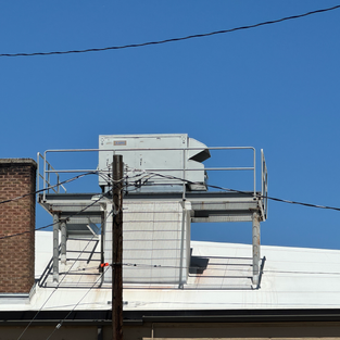 Brick chimney, TPO roof, and roof mounted HVAC unit on light industrial building. Northline Commercial Inspection Idaho