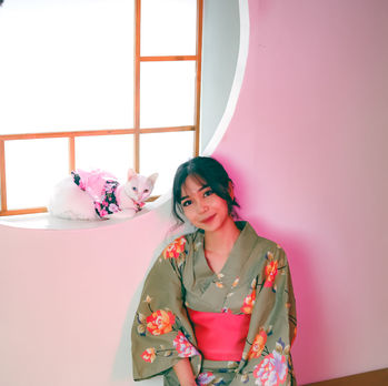 A Japanese woman sitting beside the window, with her white cat on the oriental garden at Alleycat Studio
