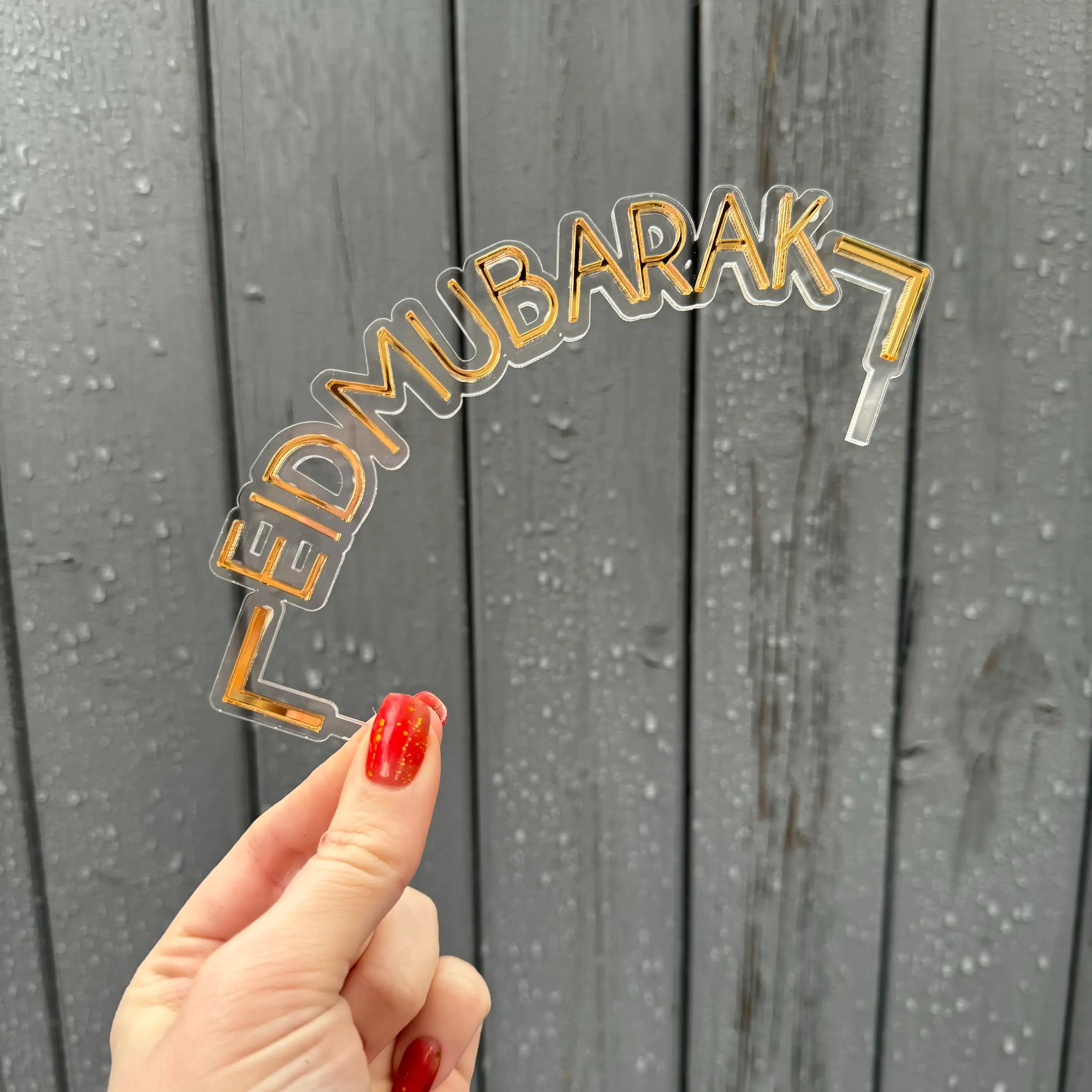 Hand holding golden Eid Mubarak sign
