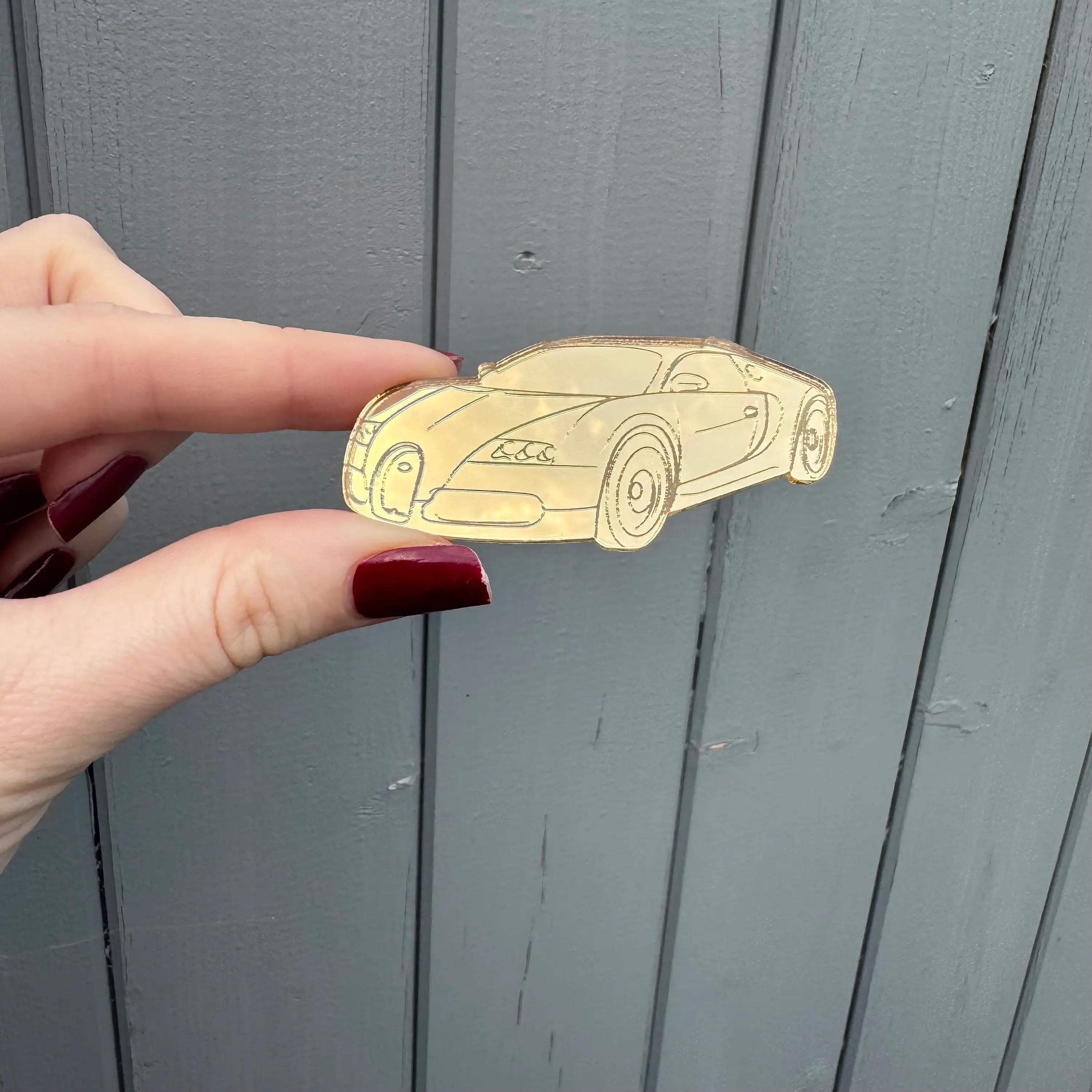 Hand holding small gold car