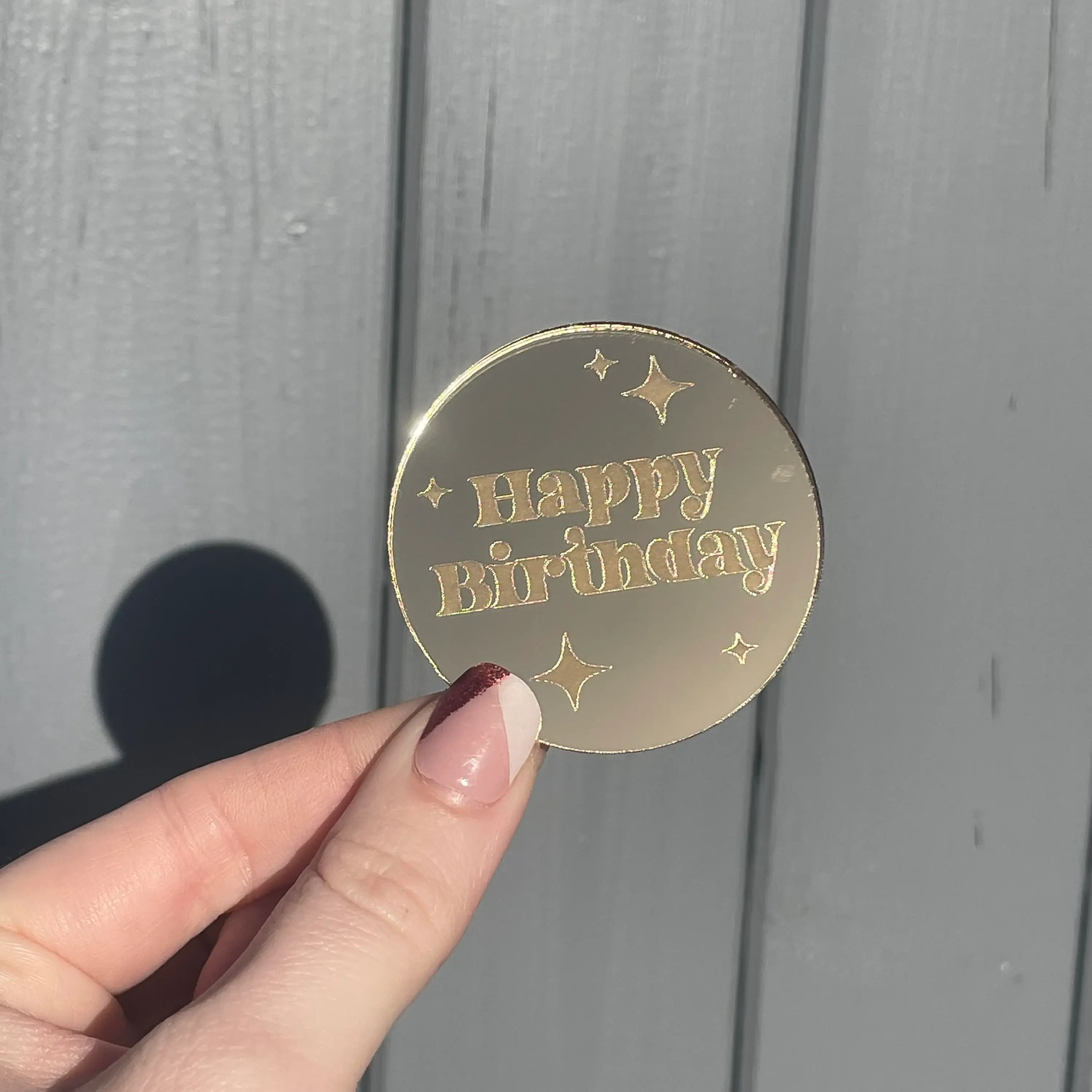 Hand holding gold 'Happy Birthday' disc