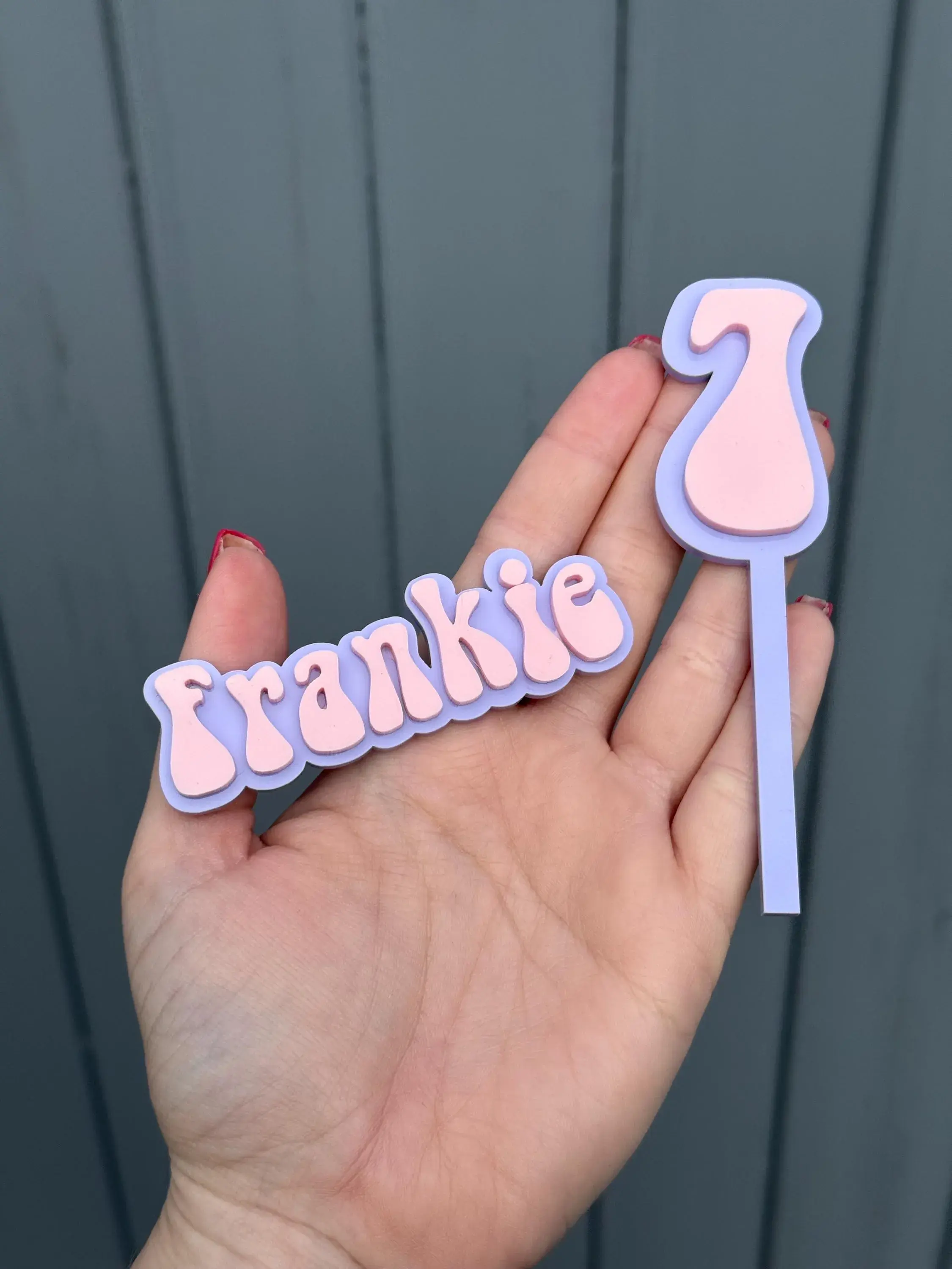 Hand holding double layer "Frankie" name and "2" age cutouts