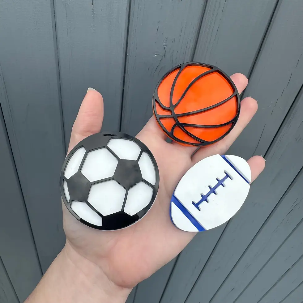Hand holding soccer ball, basketball, and football shapes