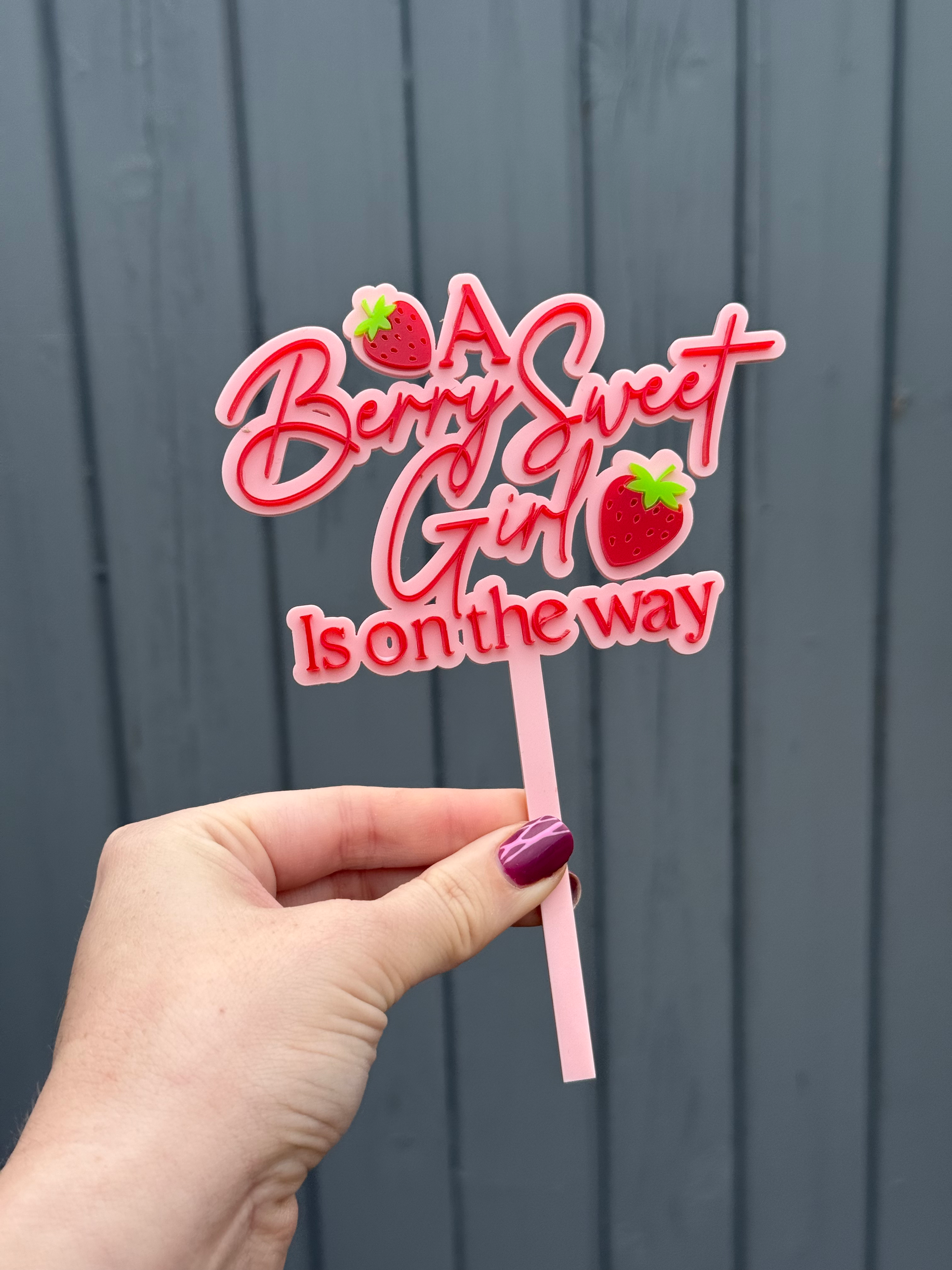 Cake topper with 'A Berry Sweet Girl Is on the way' text