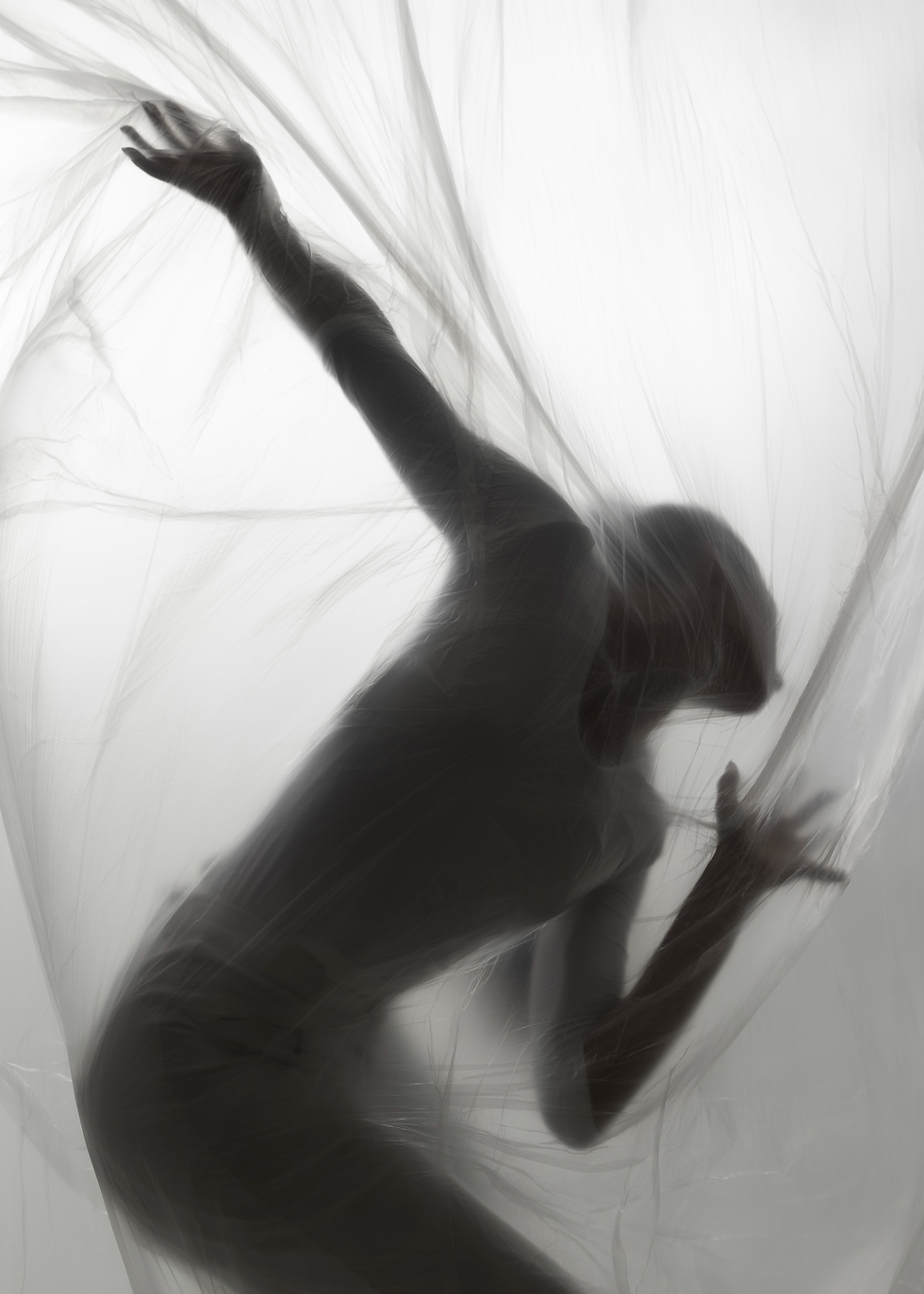 silhueta de uma pessoa atras de um tecido em preto e branco