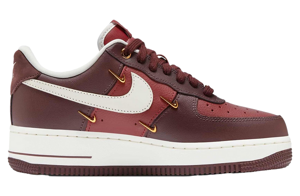 Bordo ve beyaz spor ayakkabı, Nike logosu ön planda. Altın detaylar, dikişler ve yumuşak deri dokusu dikkat çekiyor. Arka plan yok.