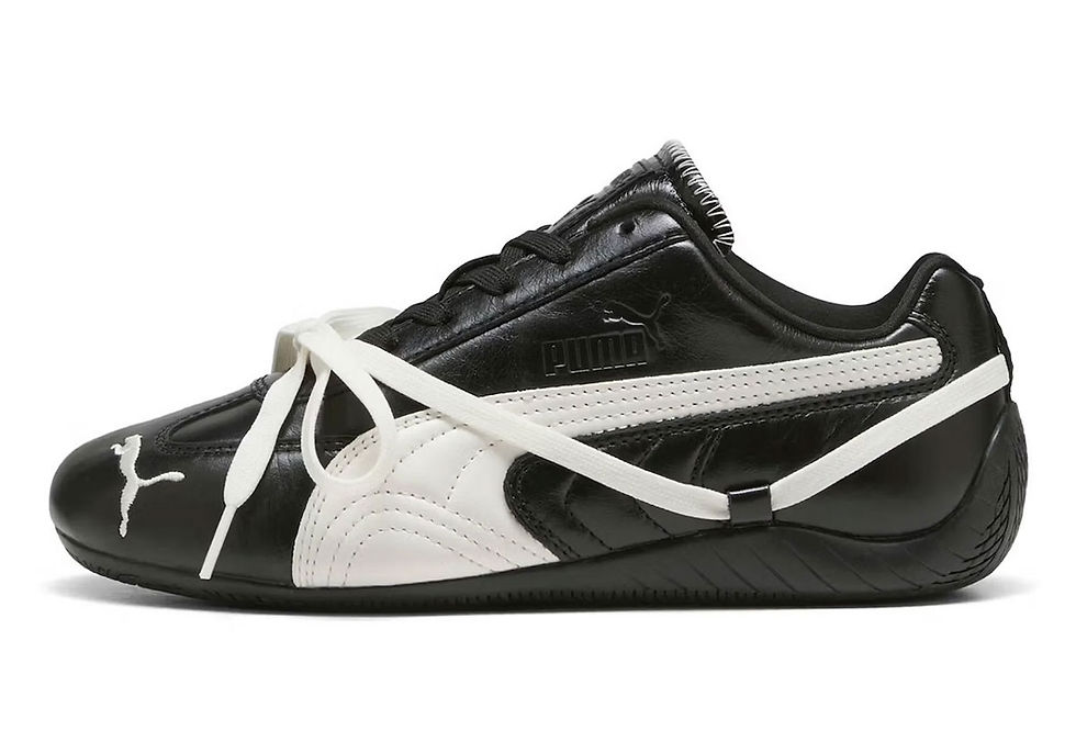 Siyah-beyaz Puma spor ayakkabı, yandan görünüm. Beyaz bağcıklar üstten bağlı. Yanında ve burnunda beyaz Puma logosu var.