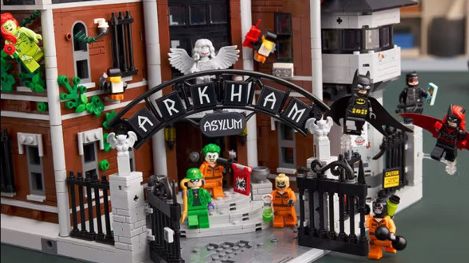 Lego figürler Arkham Asylum önünde. Joker, Batman, kötü karakterler. Siyah beyaz ARKHAM tabelası. Canlı renkler, neşeli atmosfer.
