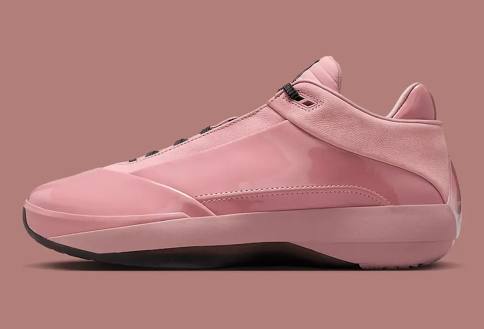 Pembe spor ayakkabı, parlak deri yüzey ve siyah tabanla. Arka planda uyumlu pembe ton var. Yan profilden görünüm.