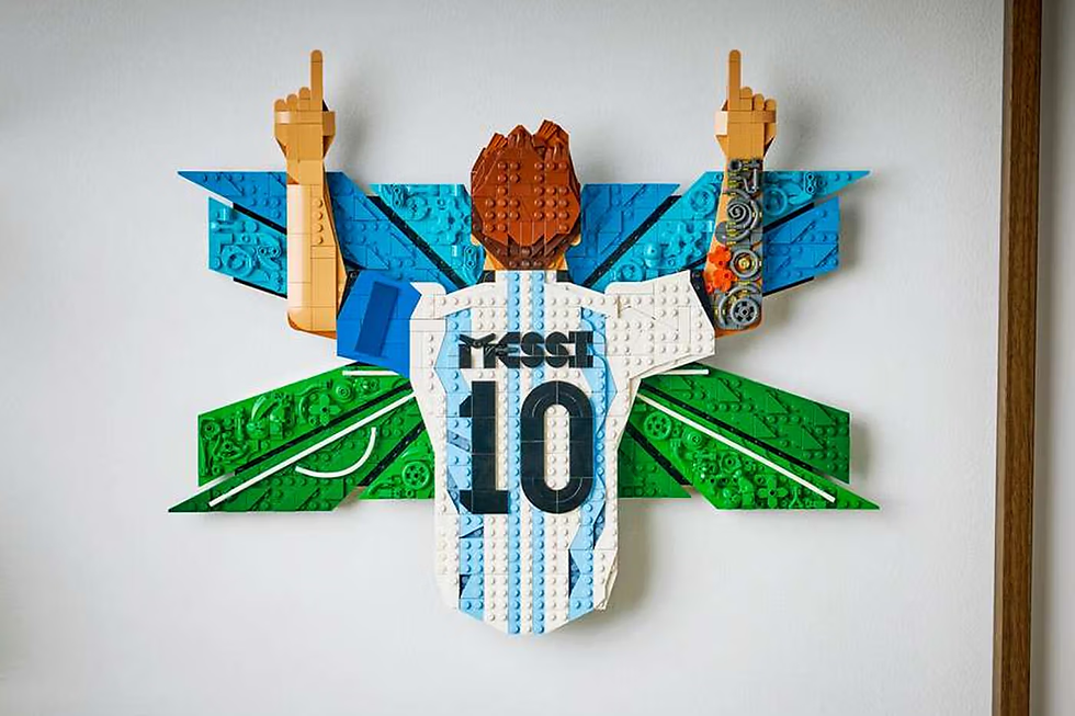 Lego parçalarından yapılmış, arkasında "MESSI 10" yazılı forma giyen figür, mavi ve yeşil fon önünde kollarını havaya kaldırmış.