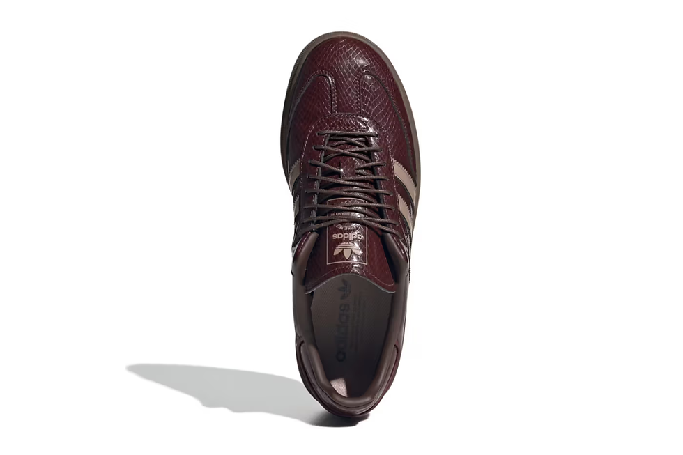 Kahverengi deri spor ayakkabı, üstten görünüm. Üzerinde üç beyaz şerit var. Ayakkabının iç tabanında Adidas logosu bulunuyor.