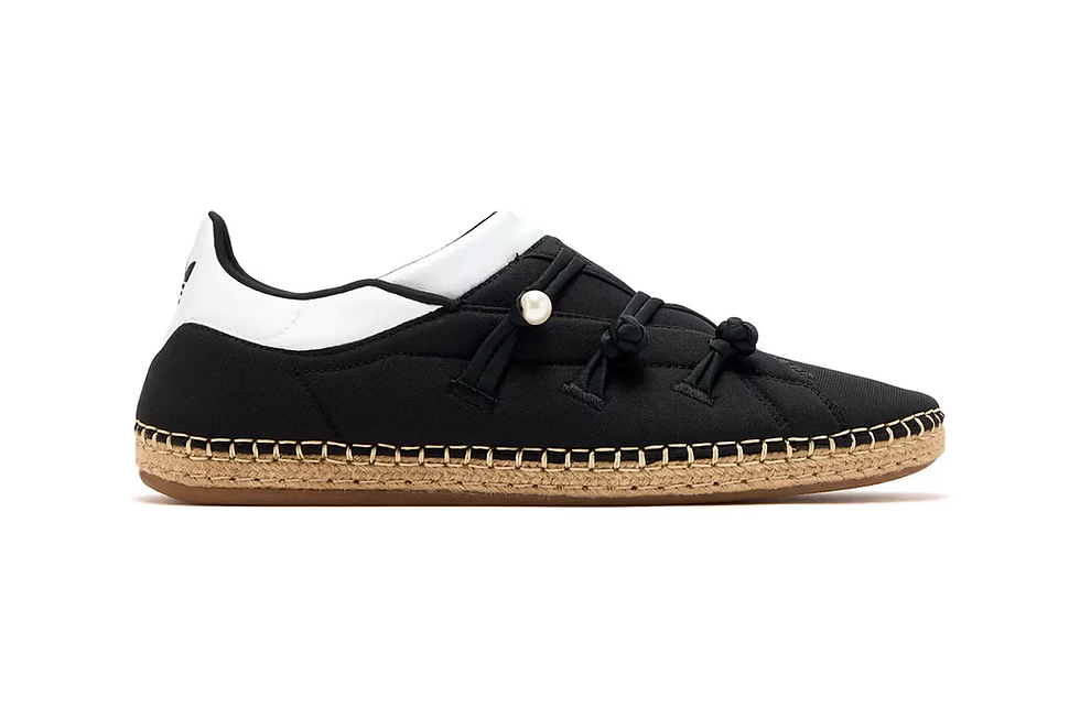 Siyah ve beyaz espadril, saman tabanlı. Bağcıklarda inci detayları var. Arka planda beyaz fon. Rahat ve şık tasarım.