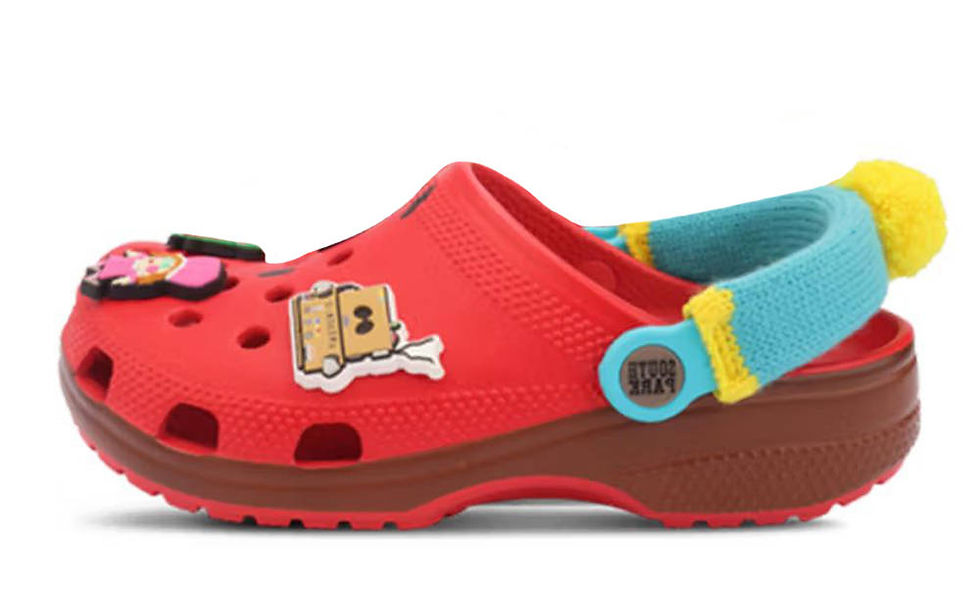 Kırmızı bir Crocs terlik, üzerinde çizgi film figürleri var. Turkuaz kayışta "SOUTH PARK" yazısı ve sarı top detayları bulunuyor.
