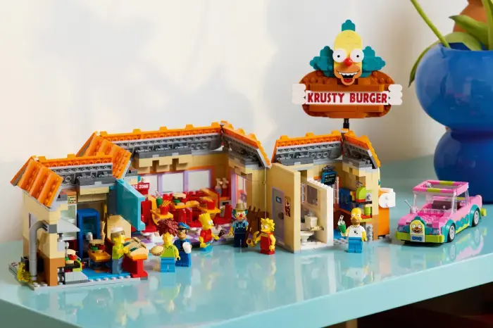 Lego Krusty Burger set with mini-figures engaging in activities. Bright colors, sign reads "Krusty Burger." Playful, vibrant mood.