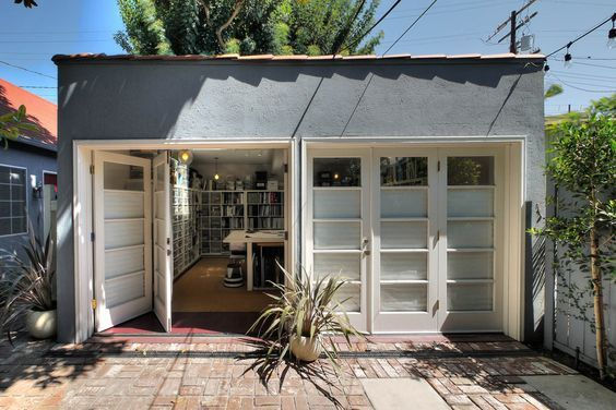 Converted garage in Orange County redesigned into a bright, multi-purpose living space with custom frosted glass doors and built-in shelving—expertly renovated by Local Construction.