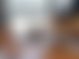 Close-up of three people at a wooden table, one holding a book and pen. A gavel is on the table, suggesting a legal setting.