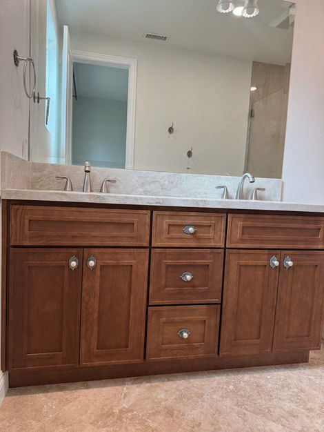 Double bathroom vanity with dark wood cabinet and light countertop