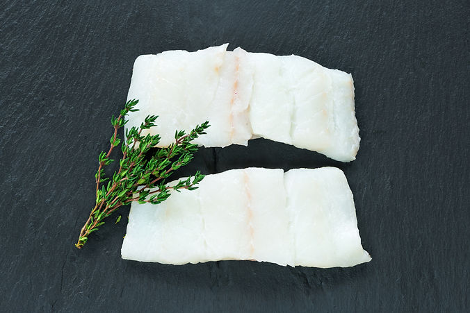 Raw haddock fillets on black board - top view.jpg