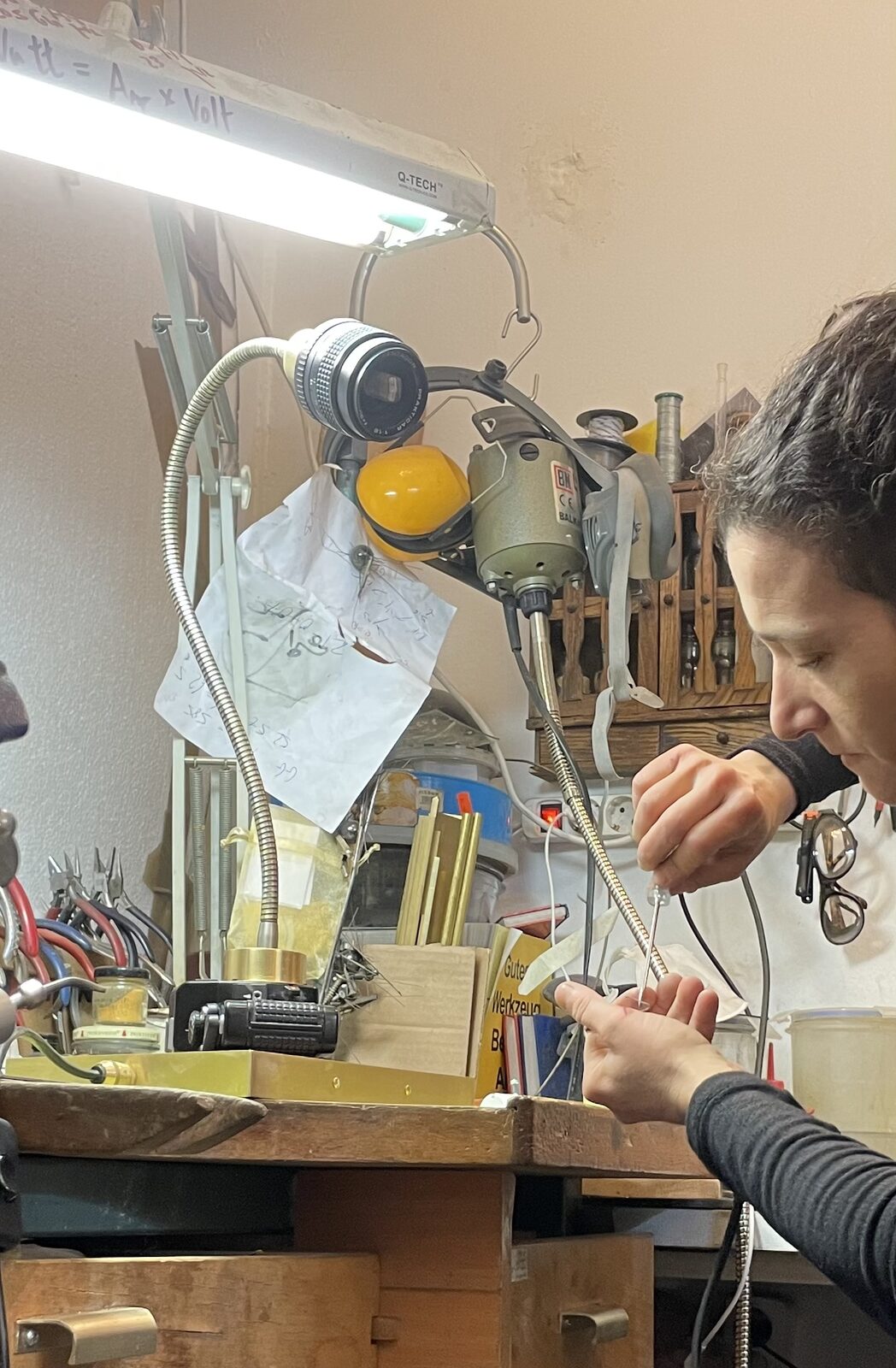 Keren at the bench working on the lamp under the lamp light