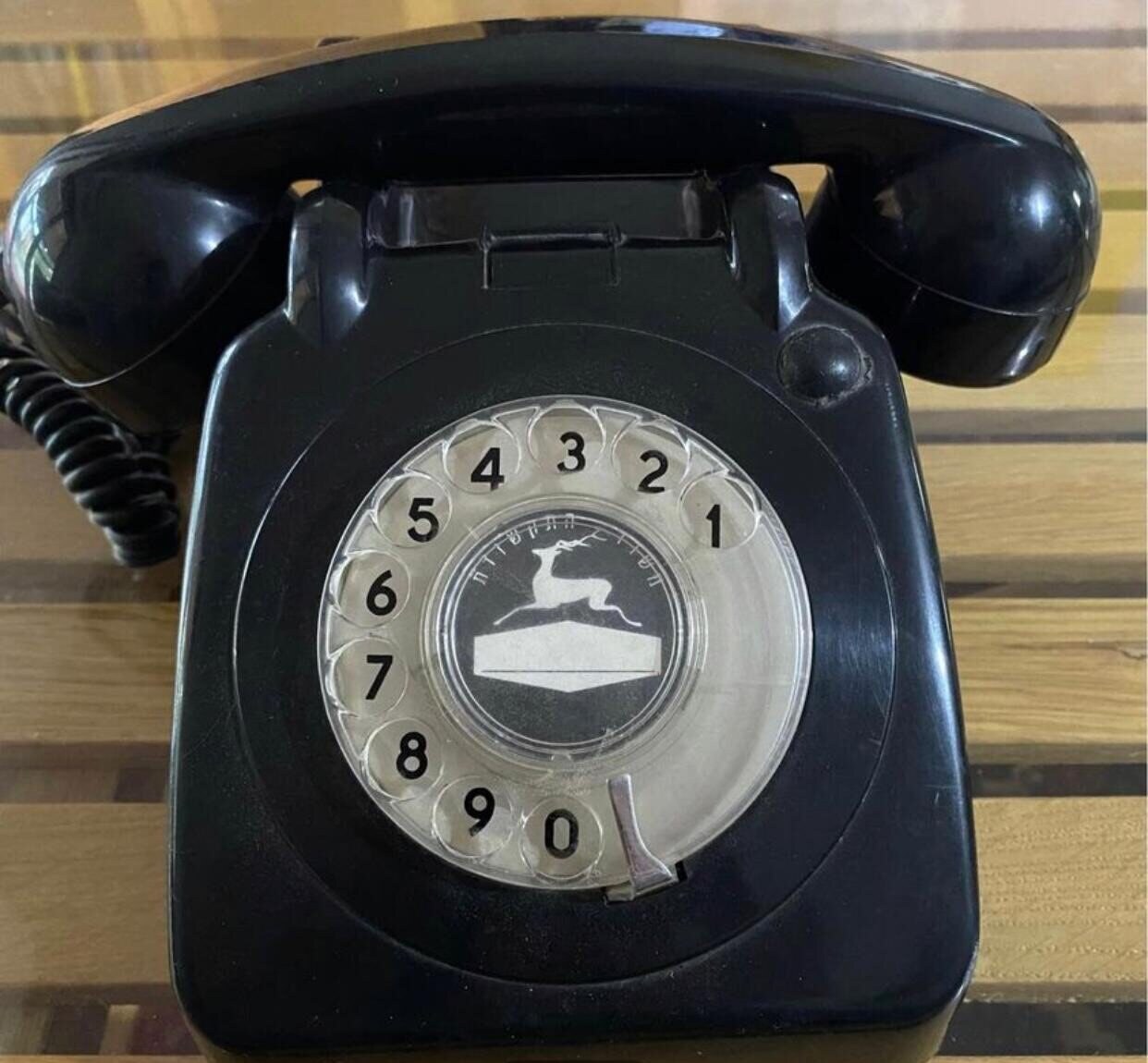 Telrad Bedside Lamp before: Black Telrad dial phone on a slatted table, 1979