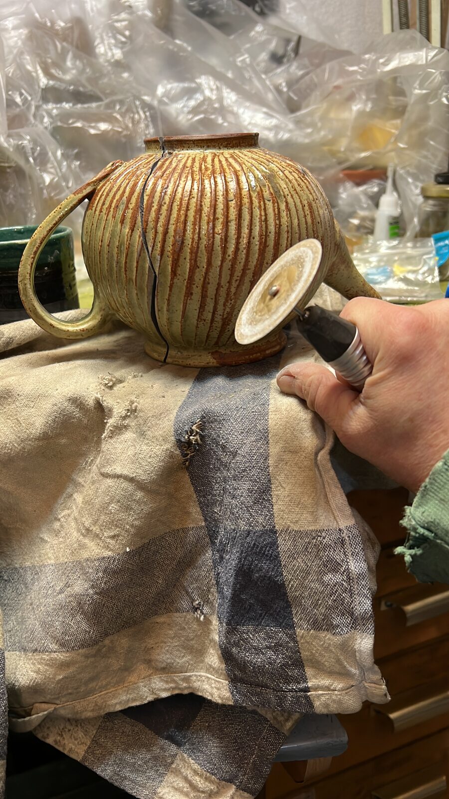 Keren drilling the teapot on a folded cloth