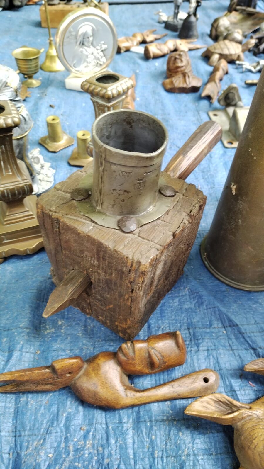 Hammer #2 before: Wooden mallet with metal cup on a flea-market blanket among brass objects