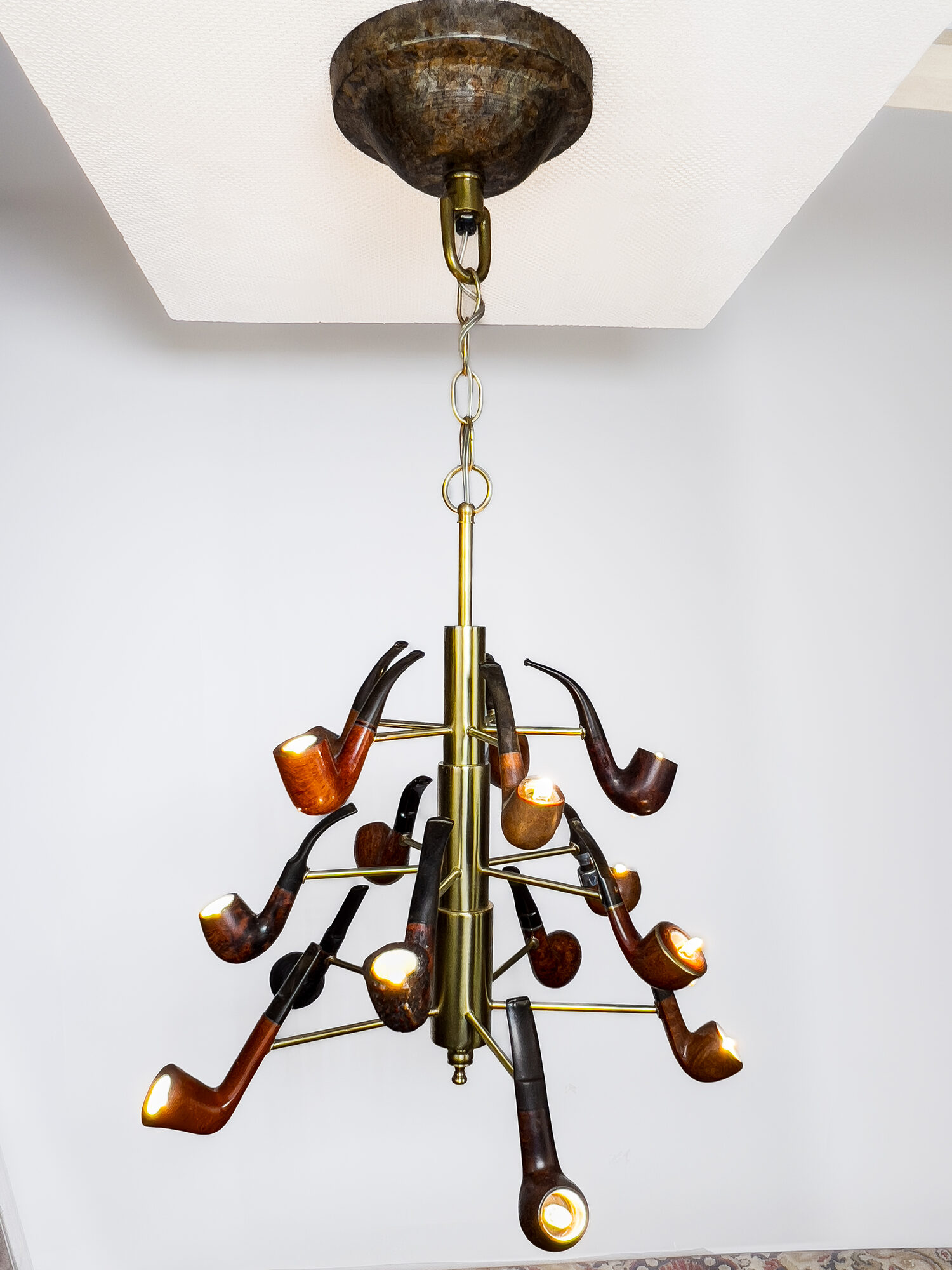 Pappa's Pipe, lit: tobacco pipes on brass arms around a brass column, a small light glowing in each bowl